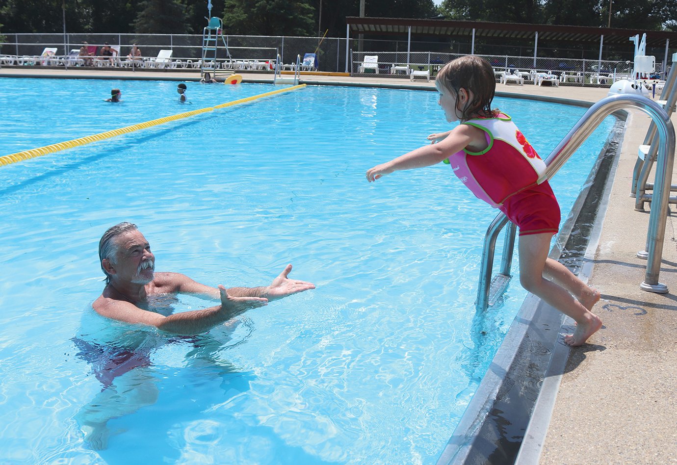 Rosalie Gleeson, 3, leaps into the Milligan Park Pool on Thursday while her father, Tim, waits to catch her.